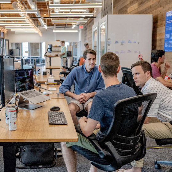 3 male colleagues discussing while sitting